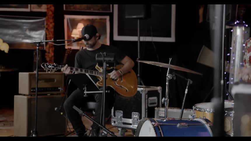 A drummer and guitarist playing on a casual stage