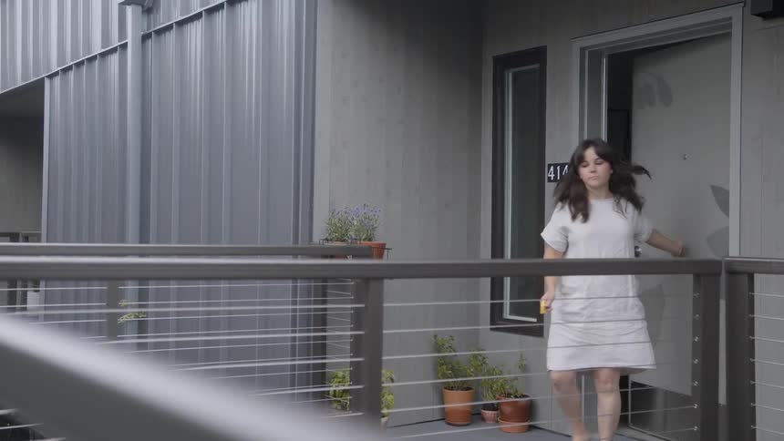 A woman leaving her front door while barefoot