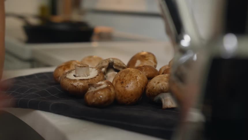 A person places mushrooms by the sink