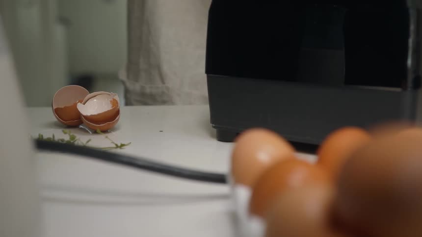 A person is breaking eggs to make a meal