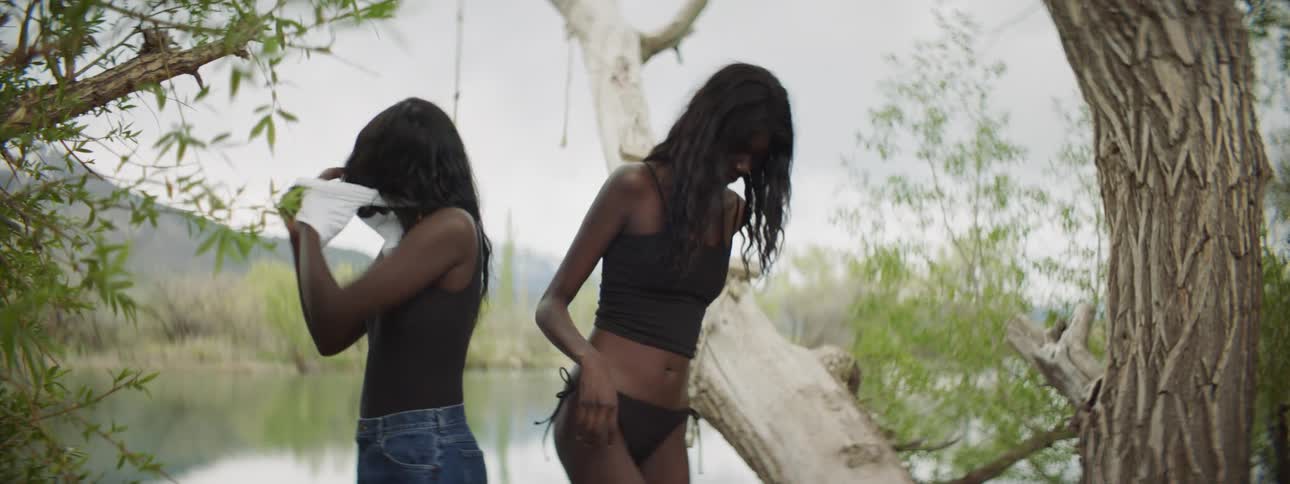 Two women taking their clothes off to go swimming