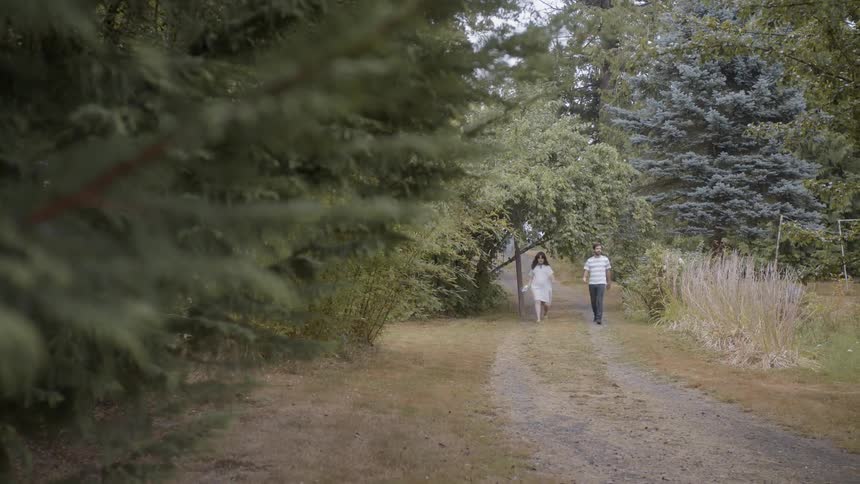 A man and woman walk on a rural dirt path