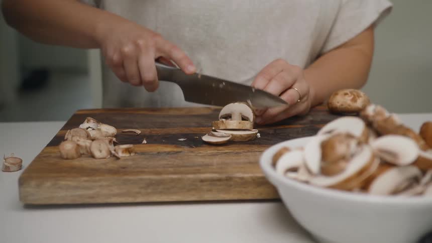 Cook chopping mushrooms on a butcher block