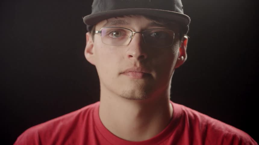 Man in hat puts on glasses