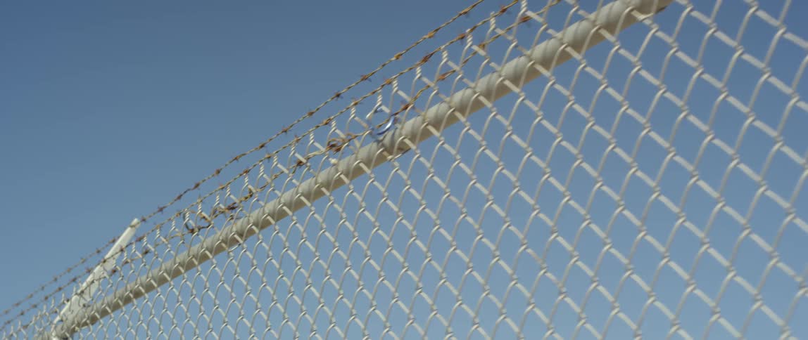 The sky is clear above the fence