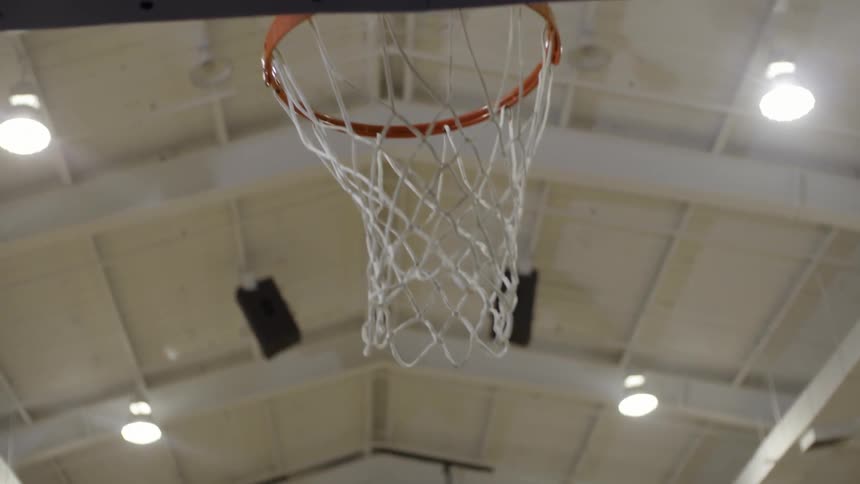 A white male teenager shoots a basketball at a hoop
