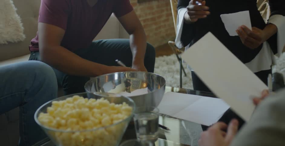 Friends play charades in a living room
