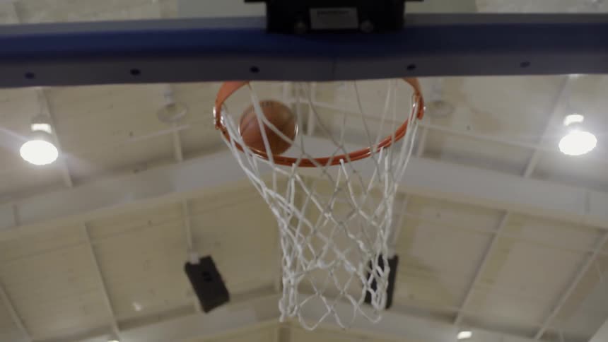 A man does a layup in a gymnasium
