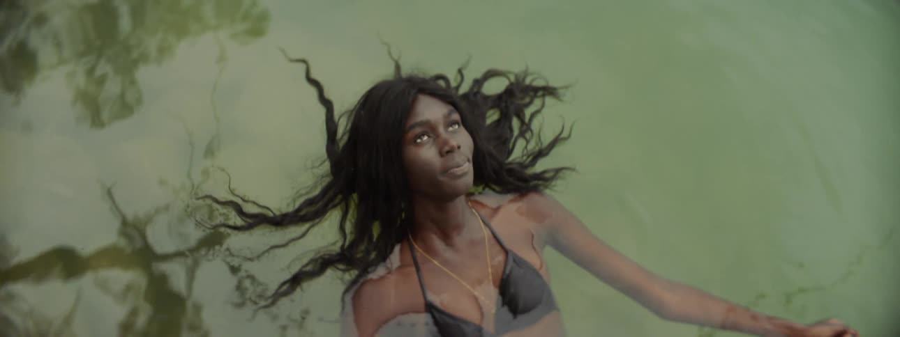 Woman wearing a bikini floating in the water with her hair floating around her head