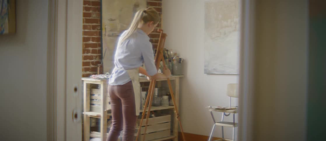 Woman propping up a painting easel