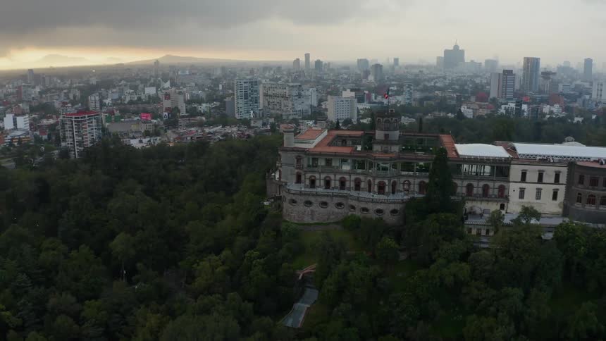 Trees surround a city building at sunset