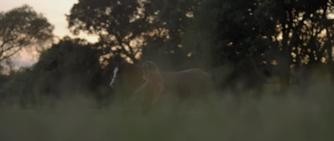 A woman is running by a horse outside