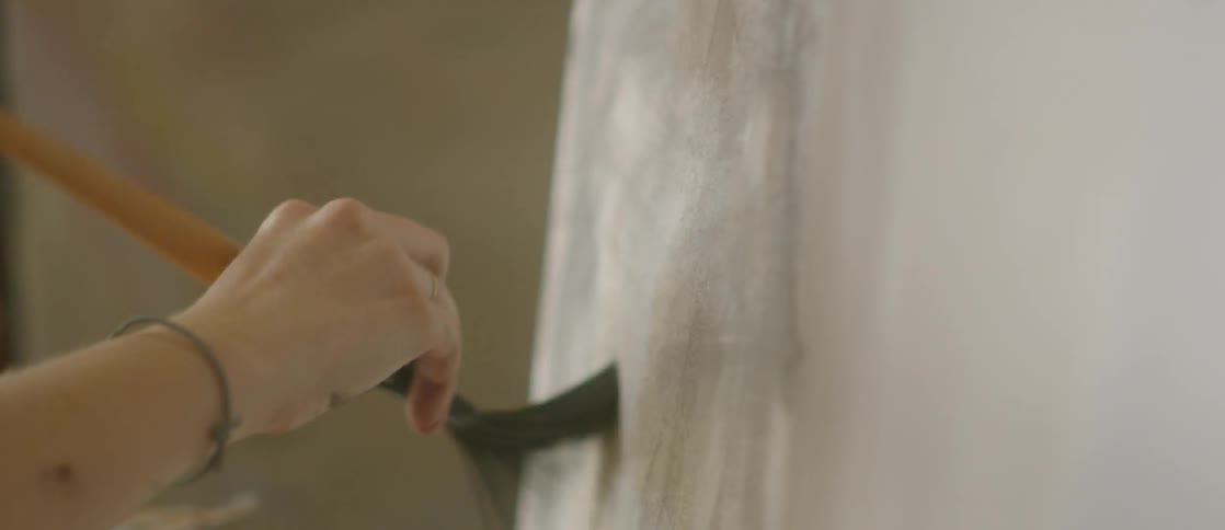 Woman applying brush strokes to a canvas