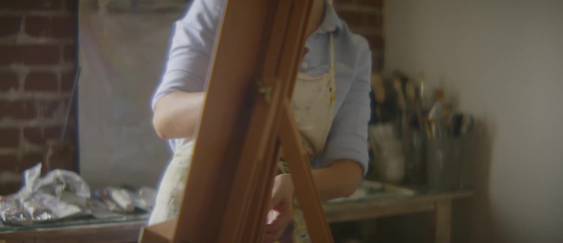 A woman is indoors painting