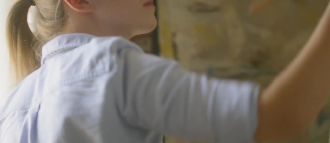 An artist brushes paint onto a canvas