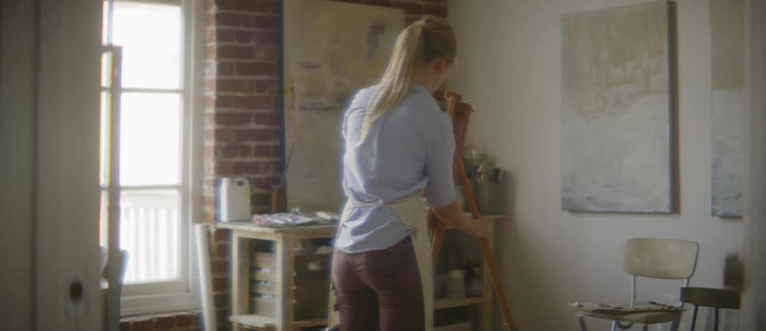 Woman propping up a painting easel