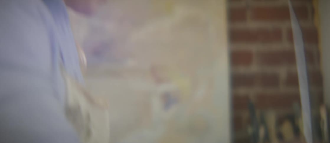 A woman paints with white paint