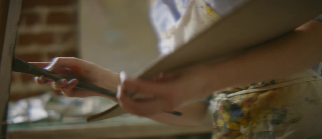 A woman is painting on a canvas