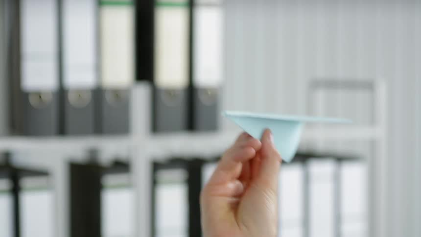 A person is throwing a paper airplane