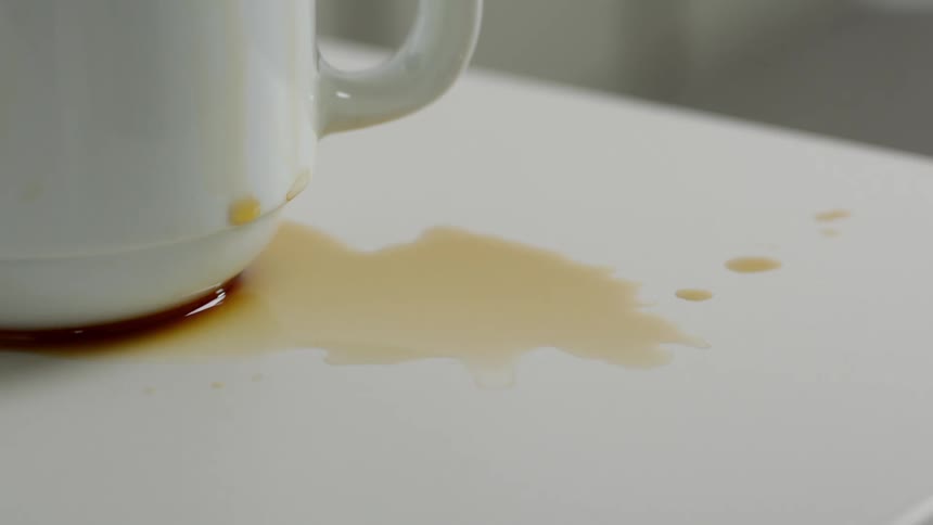 Spilled coffee covers a white table