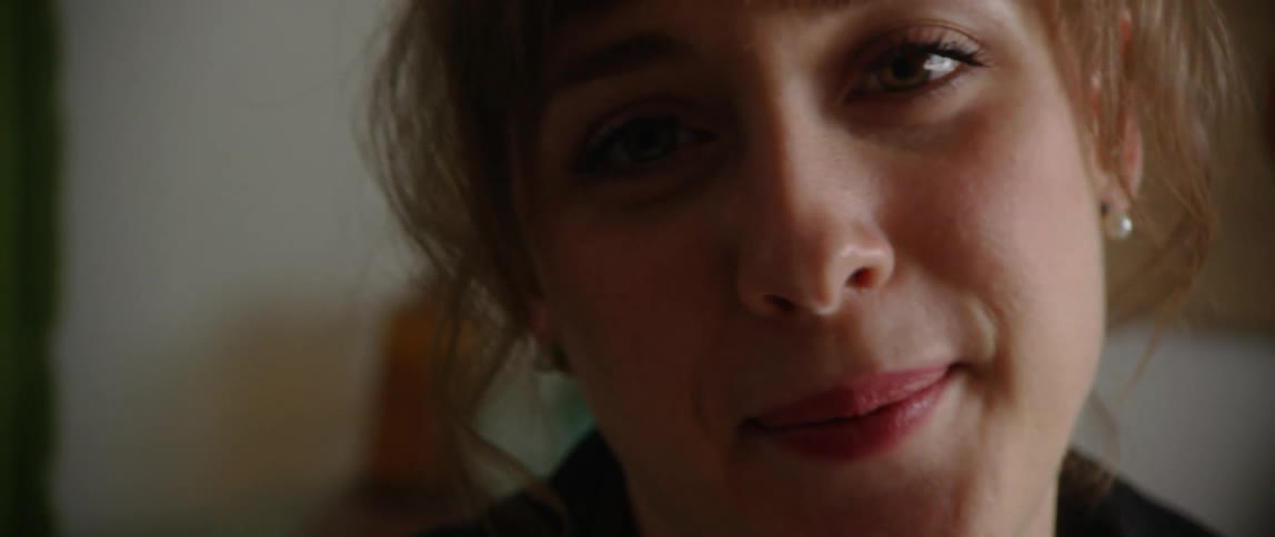 Woman with bangs rolls eyes and looks into camera
