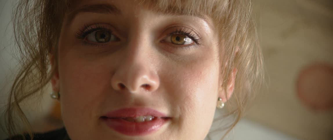 A young woman stares ahead and smiles
