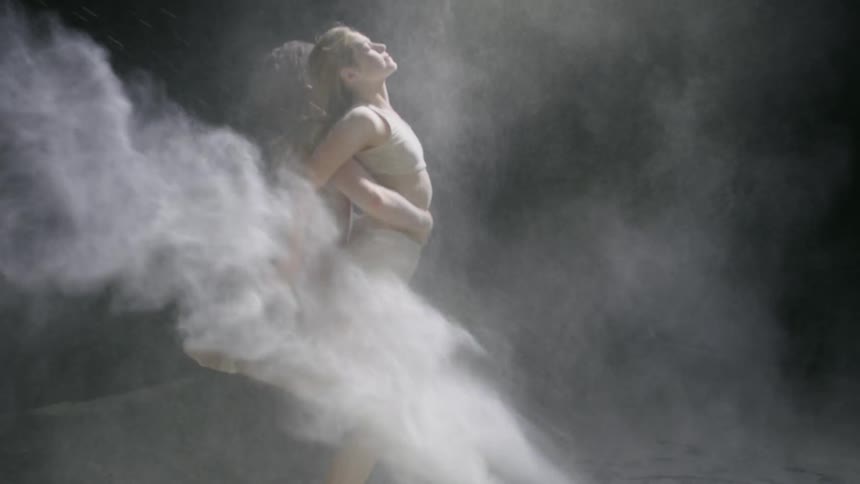 A young man and a young woman dance in clouds of chalk