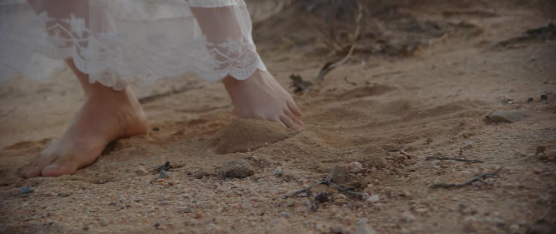 A woman is dancing in the sand