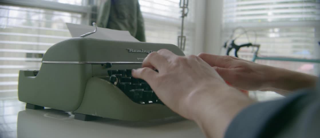 A woman types on a typewriter