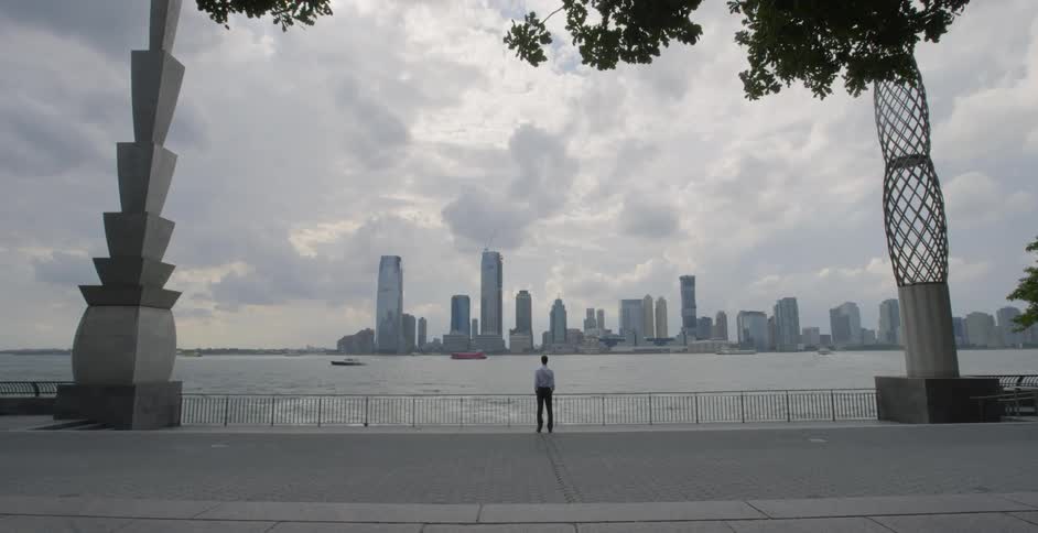 A man looks at city skyscrapers in the distance