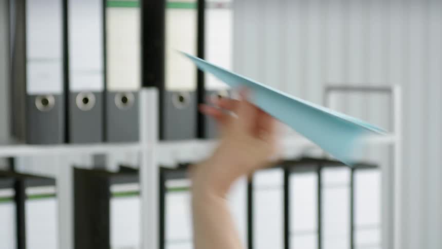A person throws a paper airplane