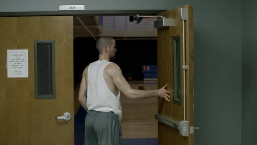 A man opens the door to a gymnasium