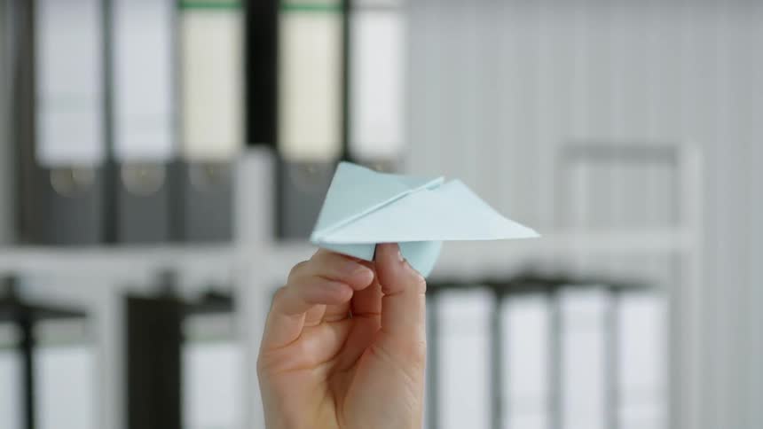 Person tossing a paper airplane