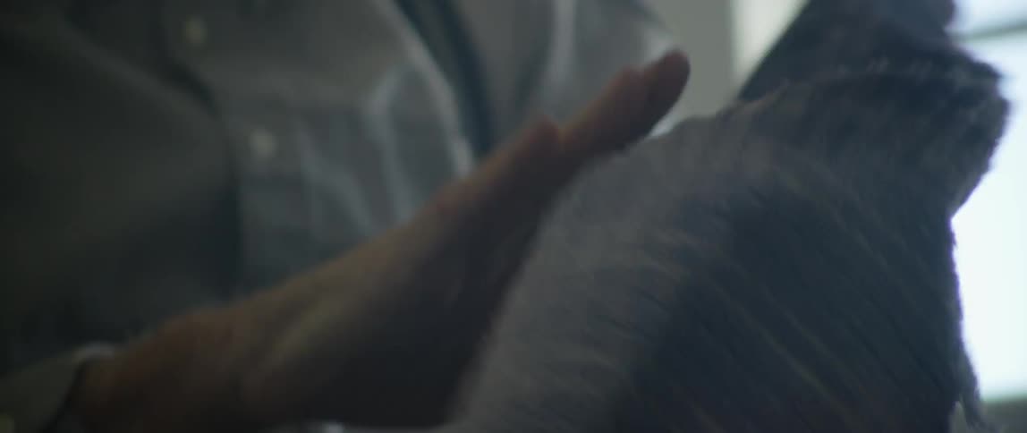 An old man dries off his hands using a towel inside at day