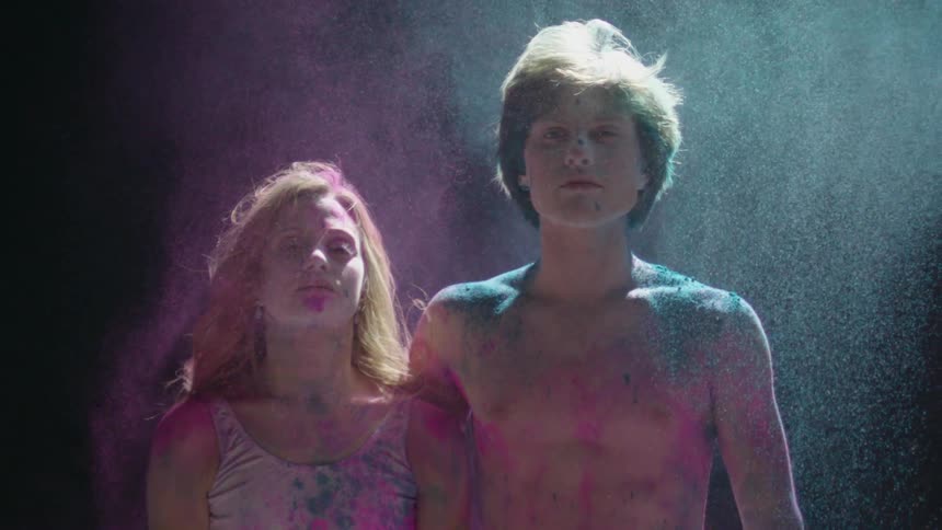 Colorful dust swirls around two dancers