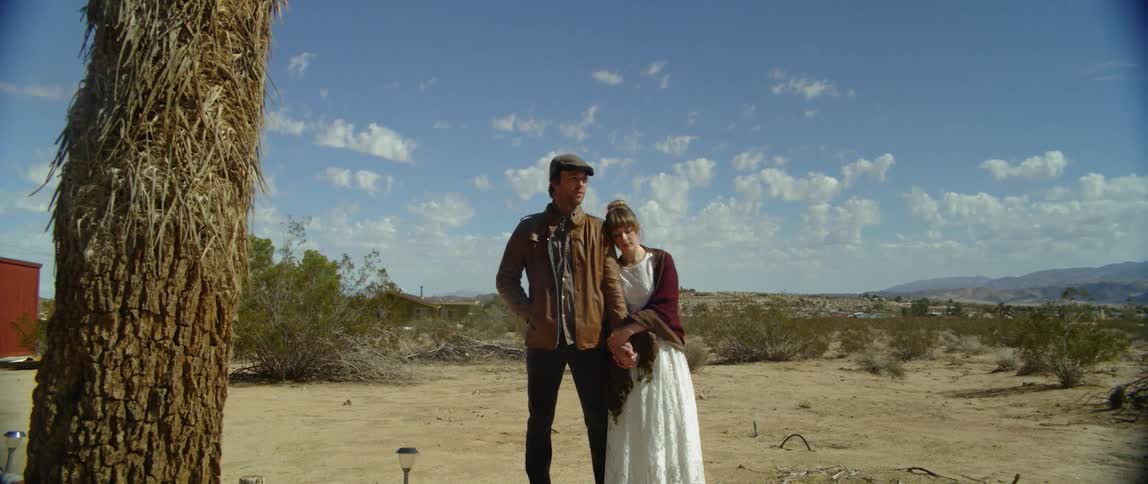 A man and woman stand in the desert together