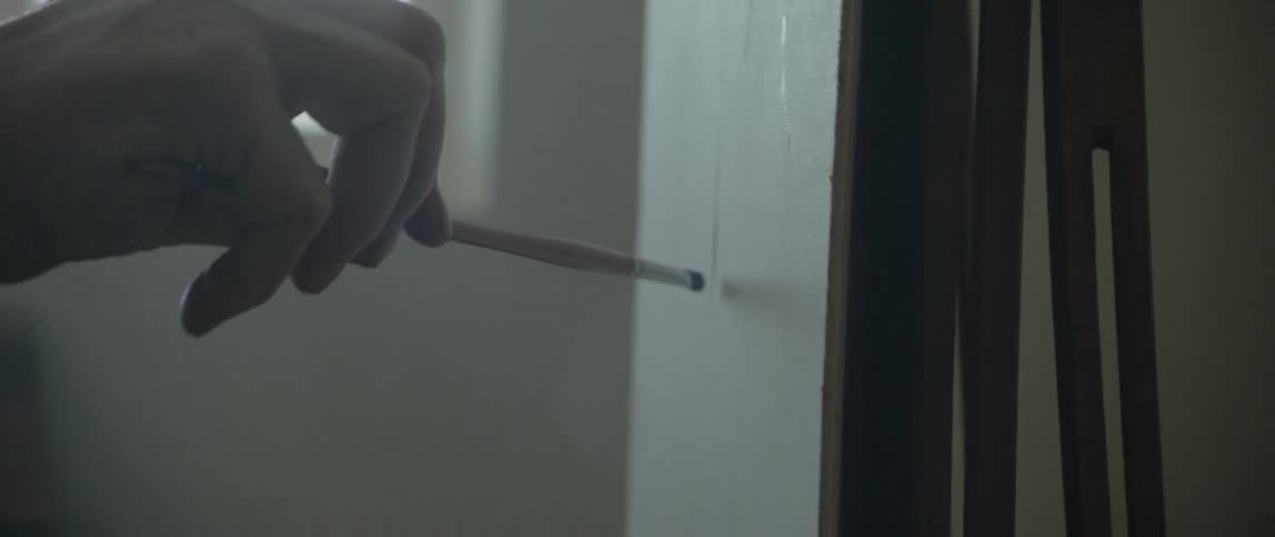 Hand paints on canvas with small brush
