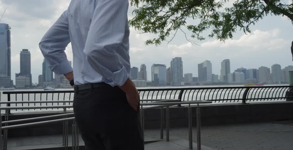 A man walking on a path next to a river