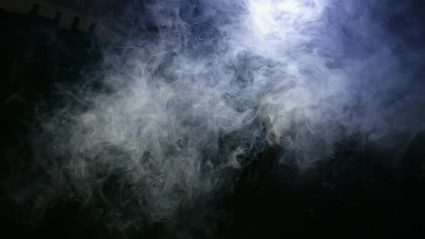 Smoke swirls in dark room
