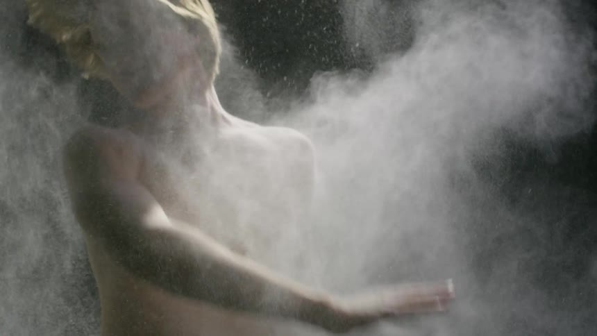 Man covered in powder flips around while more powder gets thrown on him