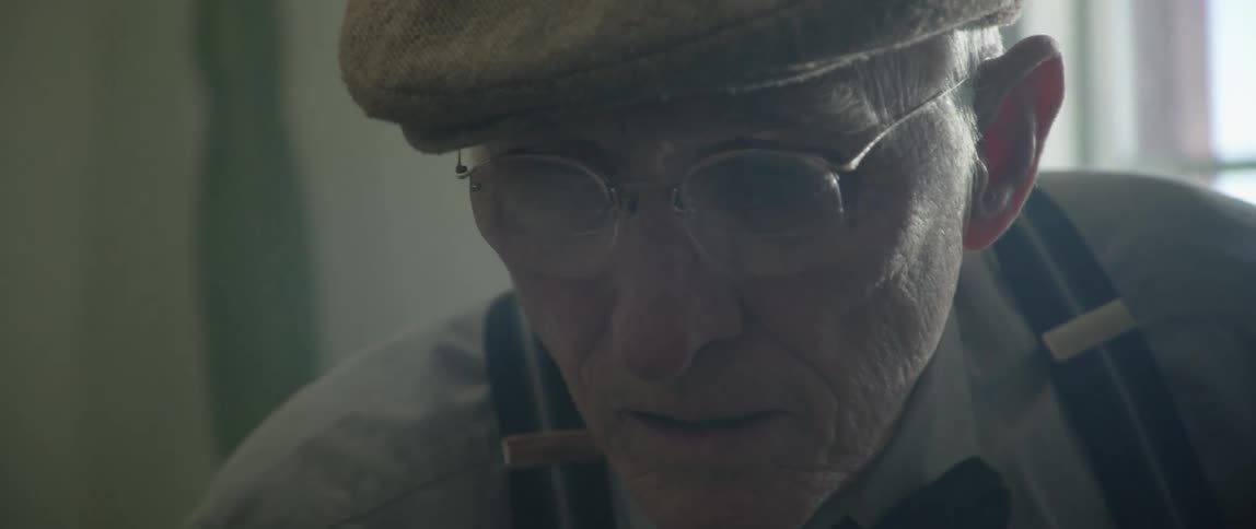Older male fiddles with an artist paint brush