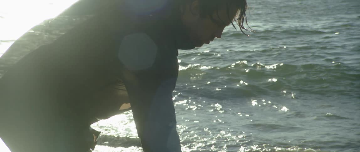 A man pulls a boat on a sunny beach