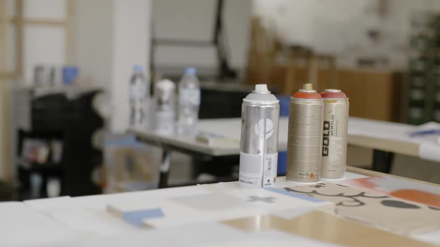 Three cans of paint sit on a table