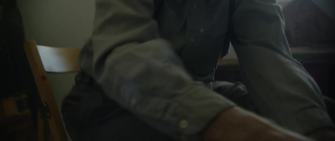 A man in a flat cap squeezes paint from a tube
