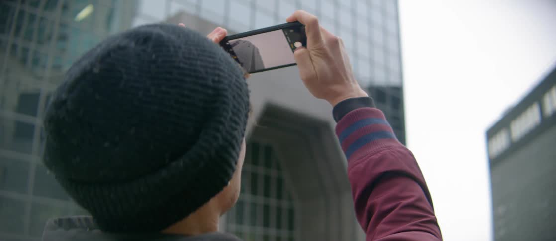 A man takes photographs of the buildings in the city