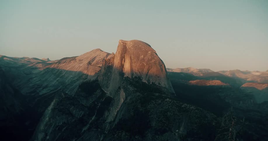 A mountain peak towers in the sunlight