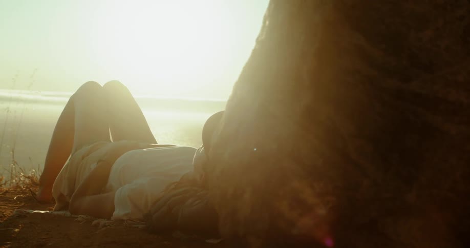 A woman lays outside under the sun