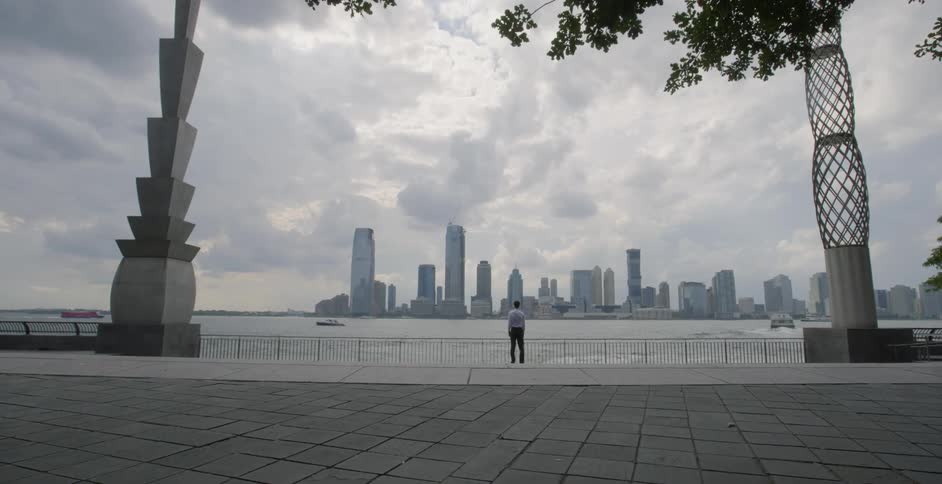 A man looking over a bay on a cloudy day