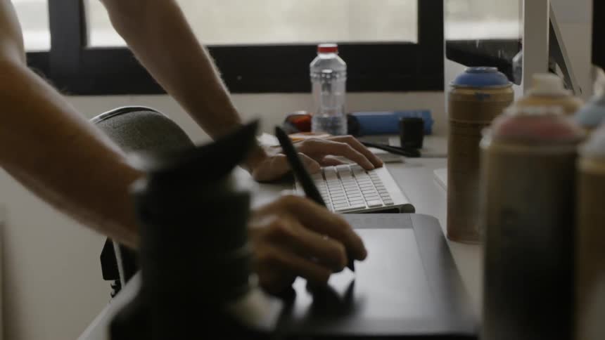 A person leans on their desk writing on a pad