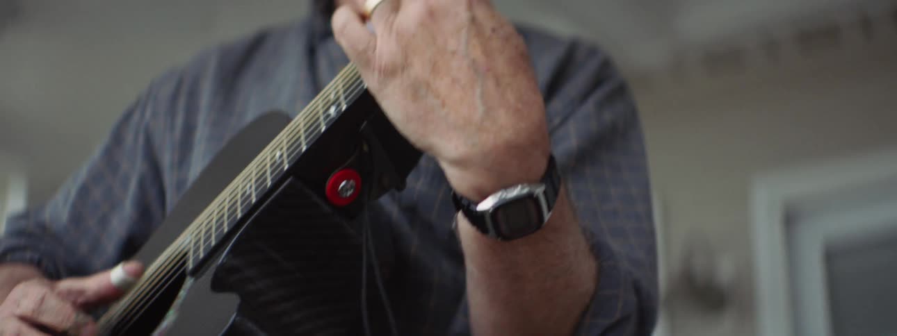 A man is playing guitar indoors